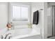 Corner bathtub with a window, shower and towel rail at 102 Williamson Place Dr, Princeton, NC 27569