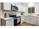 Modern kitchen featuring white cabinets, stainless steel appliances, and a view from the window over the sink at 103 Summerlin Dr Dr, Chapel Hill, NC 27514