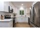 Bright kitchen with stainless steel appliances, white cabinets, and a view of the backyard through the window at 103 Summerlin Dr Dr, Chapel Hill, NC 27514
