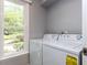 Functional laundry room with a washer, dryer, and a window showcasing a verdant landscape at 103 Summerlin Dr Dr, Chapel Hill, NC 27514