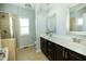 Bright bathroom featuring a double sink vanity, framed mirrors, and a glass-enclosed shower at 1041 Pemberly Ave, Morrisville, NC 27560