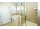 Bright bathroom featuring a soaking tub, glass-enclosed shower, and neutral tile at 1041 Pemberly Ave, Morrisville, NC 27560