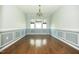 Elegant dining room featuring wainscoting, hardwood floors, and a chandelier fixture at 1041 Pemberly Ave, Morrisville, NC 27560
