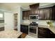 Bright kitchen features stainless steel appliances, granite counters, and ample dark wood cabinet storage at 1041 Pemberly Ave, Morrisville, NC 27560