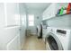 This laundry room features white cabinets over a side by side washer and dryer at 1041 Pemberly Ave, Morrisville, NC 27560