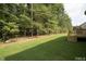 Green backyard featuring grass, trees, and a deck, perfect for outdoor enjoyment at 105 Everam Ct, Chapel Hill, NC 27516