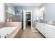 Bright bathroom featuring a tub, frameless glass shower, and a marble vanity at 105 Everam Ct, Chapel Hill, NC 27516