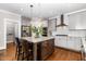 Open kitchen with a granite island, stainless steel appliances, hardwood floors, and stylish pendant lighting at 105 Everam Ct, Chapel Hill, NC 27516