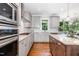 Modern kitchen with stainless steel appliances, granite countertops, gray cabinets, and hardwood flooring at 105 Everam Ct, Chapel Hill, NC 27516