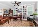 Bright office featuring built-in bookshelves, ceiling fan, window shutters, and a classic wooden desk at 105 Everam Ct, Chapel Hill, NC 27516