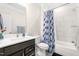 Bathroom featuring a shower with gray and white tile and a dark vanity with white countertop at 106 Garrison Farm Rd, Mebane, NC 27302