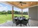 Inviting covered patio with dining set, ceiling fan, and view of the spacious backyard and mature trees at 106 Garrison Farm Rd, Mebane, NC 27302