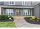 Inviting front porch with stained wood columns and walkway with manicured landscaping at 106 Garrison Farm Rd, Mebane, NC 27302