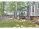 View of the backyard with a screened-in porch and lush lawn surrounded by mature trees at 106 Rock Nest Ct, Morrisville, NC 27560