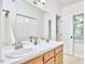 Well-lit bathroom with double sinks and a view to the outside at 106 Rock Nest Ct, Morrisville, NC 27560