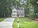 Well-maintained two-story home with a manicured lawn, mature trees, and a long driveway at 106 Rock Nest Ct, Morrisville, NC 27560
