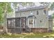 Exterior view of the home, featuring a screened-in porch, bay window and partial brick foundation at 106 Rock Nest Ct, Morrisville, NC 27560