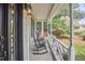 Inviting porch with rocking chairs, decorative railings, and leafy outdoor scenery at 106 Rock Nest Ct, Morrisville, NC 27560