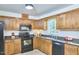 Well-lit kitchen featuring wood cabinets, dark granite countertops, and modern appliances at 106 Rock Nest Ct, Morrisville, NC 27560