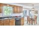 Kitchen and breakfast nook with a view outside, featuring wood cabinets and black appliances at 106 Rock Nest Ct, Morrisville, NC 27560