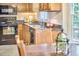 Updated kitchen with wood cabinetry and stainless steel sink, illuminated by natural light at 106 Rock Nest Ct, Morrisville, NC 27560