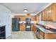 Kitchen showcasing wood cabinets, black appliances, and granite countertops at 106 Rock Nest Ct, Morrisville, NC 27560