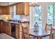 Kitchen dining area with wood cabinets, dark countertops, and natural light from the window at 106 Rock Nest Ct, Morrisville, NC 27560