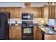 Well-equipped kitchen with black appliances, wooden cabinets, and dark countertops for a modern look at 106 Rock Nest Ct, Morrisville, NC 27560
