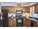 Functional kitchen boasting black appliances, ample wood cabinetry, and dark countertops at 106 Rock Nest Ct, Morrisville, NC 27560