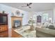 The living room has hardwood floors, a fireplace, ceiling fan and large windows at 106 Rock Nest Ct, Morrisville, NC 27560