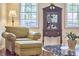 Comfortable armchair and ottoman bathed in light from the windows, and a dark wood cabinet at 106 Rock Nest Ct, Morrisville, NC 27560