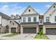 Exterior view of new townhomes, each with an attached garage and brick facade at 109 Periwinkle Pl, Clayton, NC 27527