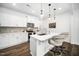 The kitchen features white cabinets, stainless steel appliances, a spacious island, and modern pendant lighting at 109 Periwinkle Pl, Clayton, NC 27527