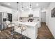Modern kitchen featuring white cabinets, stainless steel appliances, a large island, and stylish bar stools at 109 Periwinkle Pl, Clayton, NC 27527