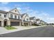 Street view of new townhomes with attached garages and well manicured yards at 109 Periwinkle Pl, Clayton, NC 27527