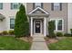 Inviting townhome entrance featuring a black door, tasteful wreath, and well-maintained landscaping at 1108 Renewal Pl, Raleigh, NC 27603
