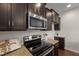 A kitchen featuring dark wood cabinetry, granite countertops, and stainless steel appliances, perfect for the home chef at 1108 Renewal Pl, Raleigh, NC 27603