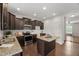 Modern kitchen with dark wood cabinets, granite countertops, stainless steel appliances, and center island at 1108 Renewal Pl, Raleigh, NC 27603