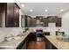 Kitchen featuring stainless steel appliances, granite countertops, dark wood cabinets, and a center island at 1108 Renewal Pl, Raleigh, NC 27603