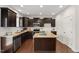 Updated kitchen featuring granite countertops, dark wood cabinetry, stainless appliances, and a center island at 1108 Renewal Pl, Raleigh, NC 27603