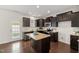 Bright kitchen featuring an island, stainless steel appliances, dark wood cabinets, and an exterior door at 1108 Renewal Pl, Raleigh, NC 27603