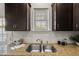 Kitchen sink with granite countertops, dark wood cabinetry, stainless steel appliances, and window at 1108 Renewal Pl, Raleigh, NC 27603