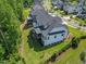 Aerial view showcasing a home with manicured lawn, adjacent to neighborhood homes and a nearby pond at 111 Stone Park Dr, Wake Forest, NC 27587