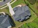 Overhead aerial view of a large roof, driveway and manicured lawn close to a pond at 111 Stone Park Dr, Wake Forest, NC 27587