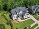 Aerial view of an estate home with manicured lawn, mature trees and dark roof at 111 Stone Park Dr, Wake Forest, NC 27587