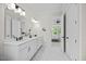 Bright bathroom featuring a double vanity, modern lighting and a doorway leading to the bedroom at 111 Stone Park Dr, Wake Forest, NC 27587