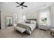 Primary bedroom features a gray upholstered bed, bench seat, and lots of natural light at 111 Stone Park Dr, Wake Forest, NC 27587