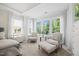 Bedroom seating area with two upholstered chairs, side table and large windows overlooking a lush landscape at 111 Stone Park Dr, Wake Forest, NC 27587