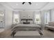 Spacious bedroom with tray ceiling, seating, and large windows covered with white sheer curtains at 111 Stone Park Dr, Wake Forest, NC 27587