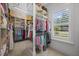 Walk-in closet with custom shelves, clothing racks and natural light from the window at 111 Stone Park Dr, Wake Forest, NC 27587